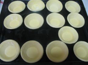 把蛋挞液用勺子舀到挞皮中，这个时候烤箱先预热200度