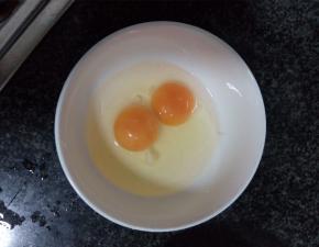 取一干净小碗，把鸡蛋打散在碗中，搅成蛋液