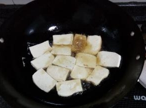 锅中热油，放豆腐片入锅煎，煎成金黄后翻面