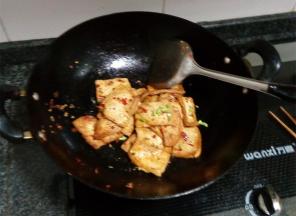 豆腐煎熟后放盐，小心翻炒均匀，撒上葱段即可