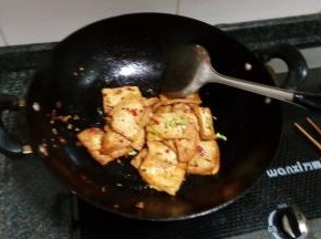 豆腐煎熟后放盐，小心翻炒均匀，撒上葱段即可
