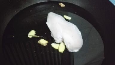 锅内加冷水，放入少量的料酒和姜片，将鸡胸放入水中煮开