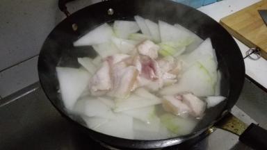 将切好的五花肉和萝卜片放入锅内，开小火