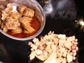 热过入油，小火爆香辅料，加入冬笋和猪蹄、花生翻炒5分钟。