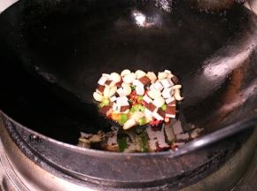 更换油锅，加青椒、干辣椒、豆干粒、姜蒜、爆香，用自制的红油、料酒、盐等调味。