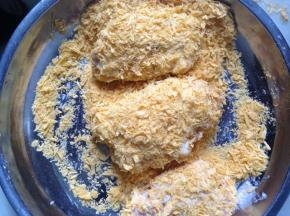将鸡翅依顺序，分别在生粉、鸡蛋液和面包糠里滚一圈