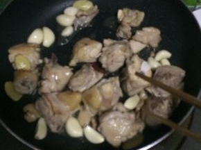 鸡腿肉煸至变色加入蒜瓣，继续煸炒至肉断生