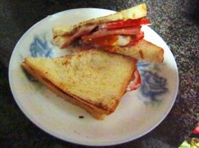 面包片上依次放上午餐肉和西红柿片，挤上色拉酱，盖上另一片面包，沿对角线切成两半即可