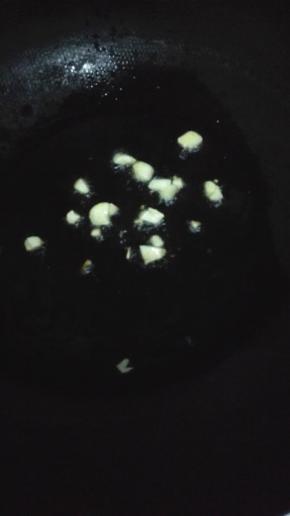 锅内放油加热，油温七成热的时候放入蒜瓣，小火炒出香味