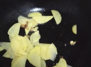 加入土豆片翻炒，炒至土豆片逐渐透明