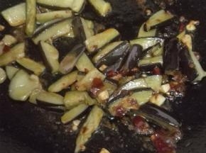 将过油的茄子放入锅内翻炒均匀