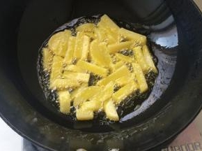 锅内多放一点油，油温七分热放入土豆条，炸至金黄即可捞出