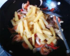 放入炸好的土豆和虾，倒入生抽，盐和鸡精，翻炒均匀即可出锅