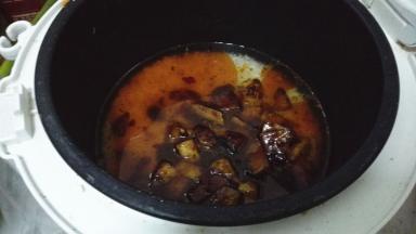 炒过的土豆放入电饭锅内，按下煮饭键