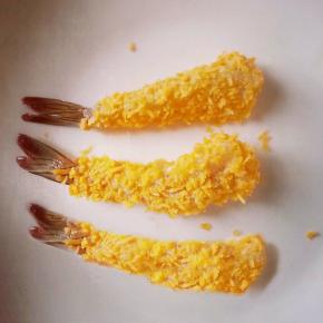 将腌好的虾先裹上一层面粉，再裹上一层蛋液，最后裹上面包糠