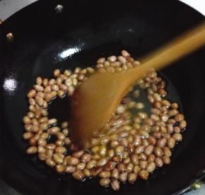 锅内放比平时炒菜多一些的油，倒入花生米翻炒至微微变色。捞出沥干