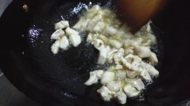 放入腌制好的鸡丁，倒入少许的料酒翻炒均匀