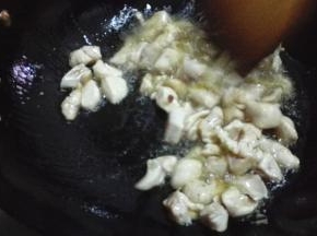 放入腌制好的鸡丁，倒入少许的料酒翻炒均匀