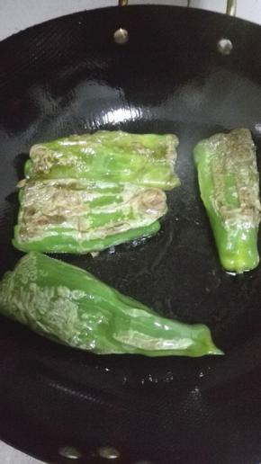 用铲子按压青椒，适时地翻动青椒，让青椒的表面出现均匀的纹理