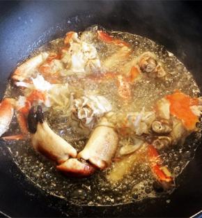 锅内放比炒菜多一点的油，油热放入螃蟹炸至金黄。捞起备用沾少许的干淀粉备用