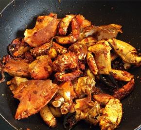 放入炸好的螃蟹，放少许的料酒和白糖，翻炒均匀