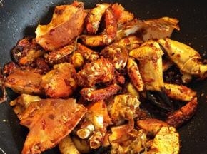 放入炸好的螃蟹，放少许的料酒和白糖，翻炒均匀