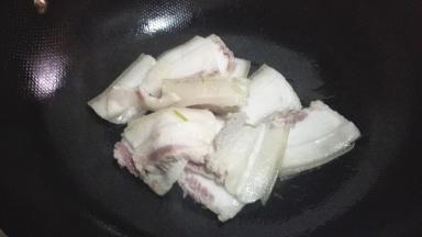 放入五花肉煸炒出肥油，炒至肉片微微卷曲