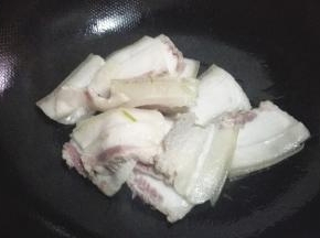 放入五花肉煸炒出肥油，炒至肉片微微卷曲