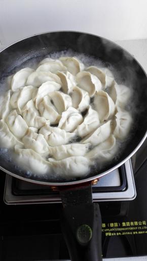饺子摆好后放入适量的清水，盖上盖煎10分钟左右
