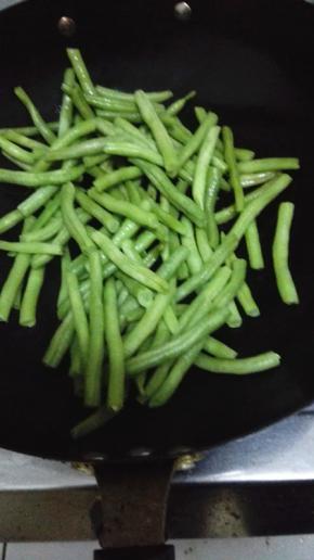 锅内放入比平时炒菜多一些的油，油热放入四季豆