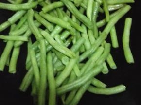 锅内放入比平时炒菜多一些的油，油热放入四季豆