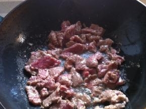 热锅冷油，放入腌制好的牛肉大火炒至变色