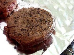 烤箱220度预热，托盘上用锡纸铺上，放上煎好的牛里脊，表面涂上盐和黑胡椒