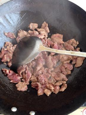 锅内倒油，油热9分热的时候放入腌制好的牛肉片翻炒