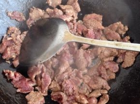 锅内倒油，油热9分热的时候放入腌制好的牛肉片翻炒
