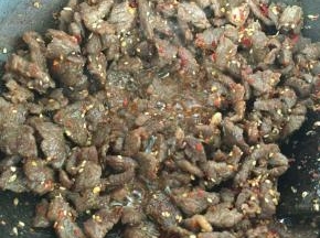 撒上准备好的芝麻，孜然和辣椒面，大火炒5分钟