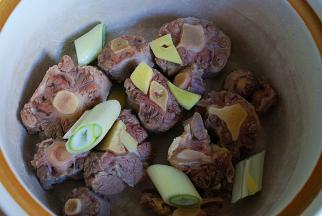 牛尾放入砂锅中，加适量的水，放入葱姜和料酒，大火煮开转至小火煮1个半小时