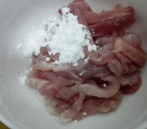 切好的猪肉放入碗中，加入适量的淀粉和水，抓拌均匀