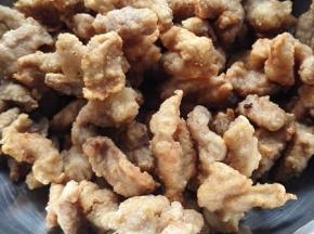 大火将油烧热，放入炸过的猪肉在炸1分钟捞出备用
