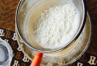 把低筋小麦粉筛入蛋液中，搅拌均匀