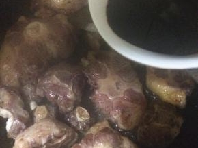 加入老抽上色，倒入料酒翻炒均匀