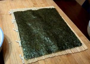 在寿司卷帘上铺上一张海苔