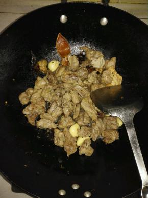 放入焯水的牛腩，倒入生抽，老抽和料酒翻炒均匀，炒至牛腩均匀上色