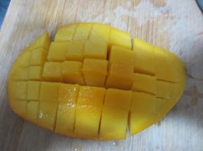 芒果切开，在果肉上划十字刀取出，放在西米上