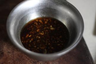 将所有的调料放入小碗中，撒上蒜末，搅拌均匀