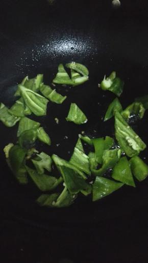 用锅内的余油翻炒青椒，炒至表皮出现褶皱的时候放入煎好的鸡蛋