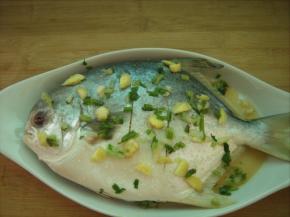 腌好的鱼身和周围铺上一层葱姜