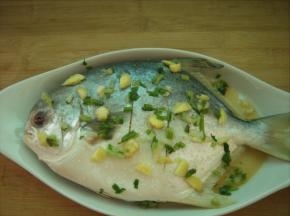 腌好的鱼身和周围铺上一层葱姜