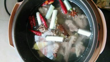 羊肉放入压力锅内，倒入葱姜和香料，加水