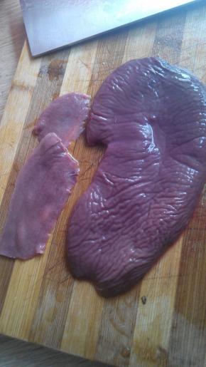 将猪腰对半切开，把白色的筋膜去掉